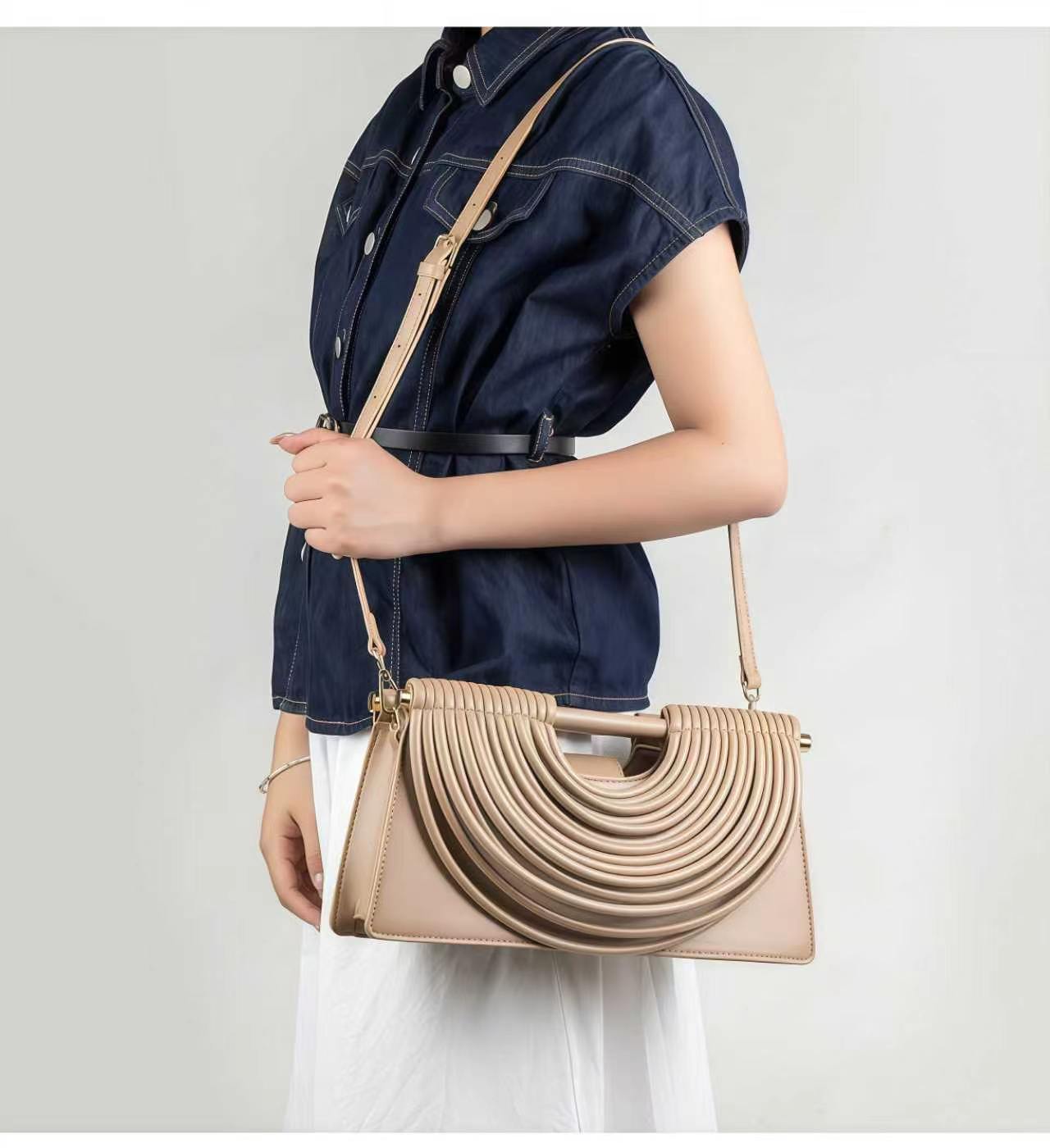 Champagne handwoven crossbody bag worn with navy blouse