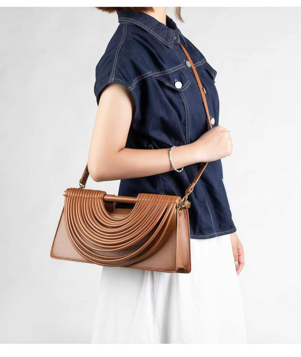 Brown handwoven crossbody bag worn with navy blouse